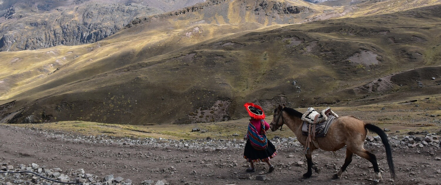 Ein Pfad in den Anden und eine Frau die ein Pferd führt