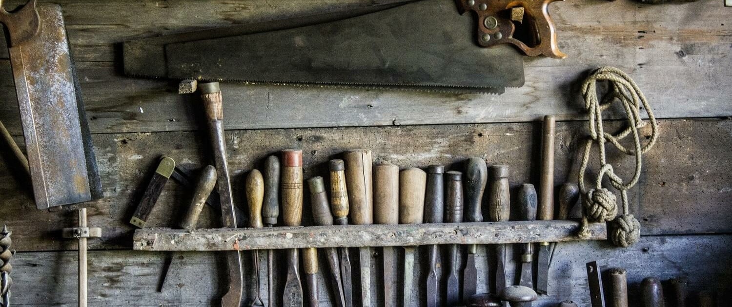 Eine Wand an der altes Werkzeug hängt